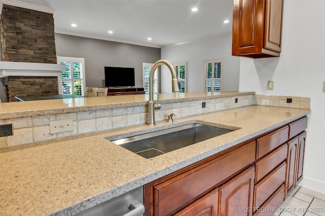 9304 E 113th St S, Bixby, OK 74008 - kitchen featuring light stone counters, recessed lighting, brown cabinets, crown molding, and light tile patterned floors