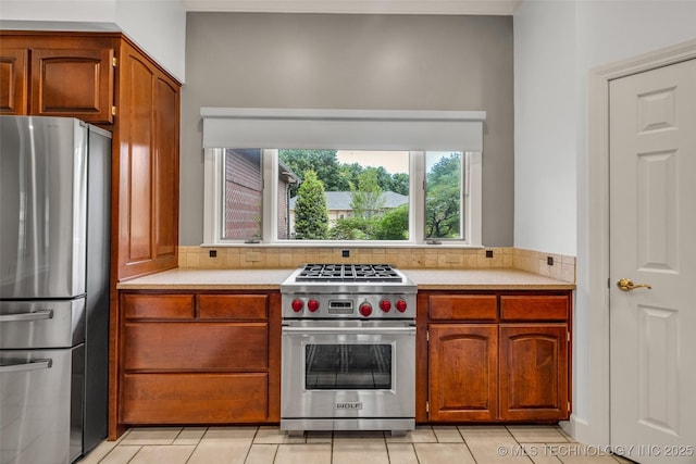 9304 E 113th St S, Bixby, OK 74008 - kitchen with appliances with stainless steel finishes, light countertops, light tile patterned floors, and brown cabinets