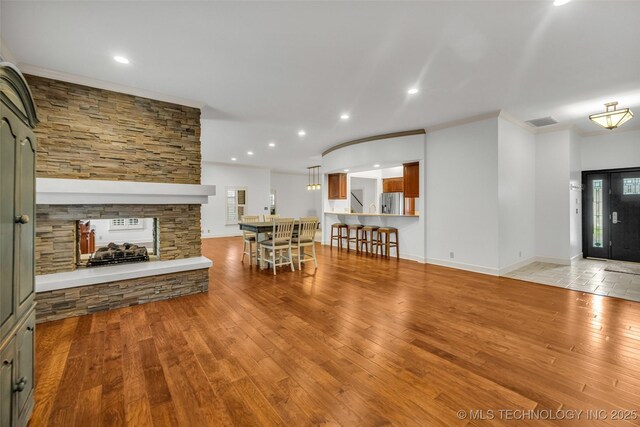 9304 E 113th St S, Bixby, OK 74008 - living room with light wood-type flooring, recessed lighting, ornamental molding, and a stone fireplace