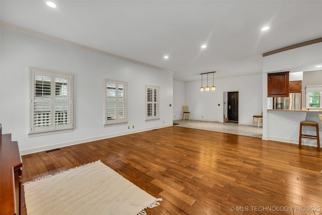 9304 E 113th St S, Bixby, OK 74008 - unfurnished living room featuring crown molding, recessed lighting, and light wood-style floors