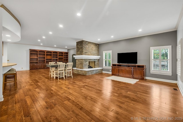 9304 E 113th St S, Bixby, OK 74008 - living room featuring ornamental molding, plenty of natural light, a stone fireplace, hardwood / wood-style flooring, and recessed lighting
