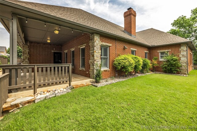 9304 E 113th St S, Bixby, OK 74008 - back of property with a chimney, brick siding, roof with shingles, and a lawn
