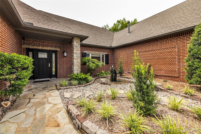 9304 E 113th St S, Bixby, OK 74008 - doorway to property featuring brick siding and a shingled roof
