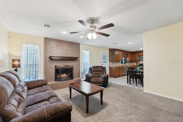 living area featuring ceiling fan, a fireplace, light carpet, a textured ceiling, and recessed lighting