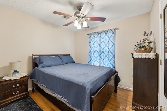 bedroom with wood finished floors, ceiling fan, baseboards, and a textured ceiling