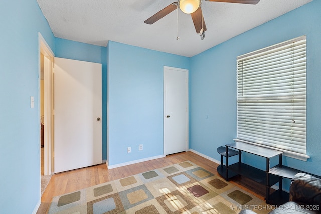 unfurnished bedroom with wood finished floors, ceiling fan, and baseboards