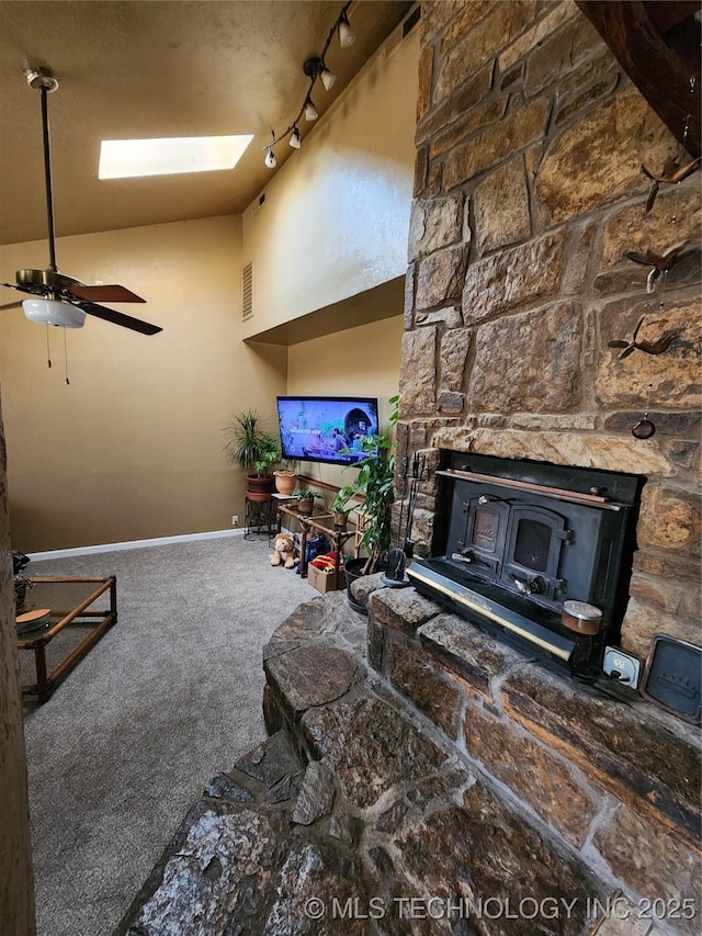 14360 County Road 3505th Loop, Ada, OK 74820 - living area with a wood stove, carpet floors, baseboards, a ceiling fan, and a skylight