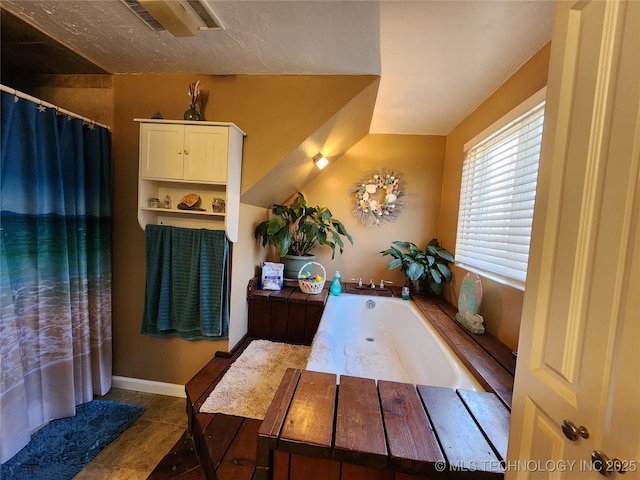 14360 County Road 3505th Loop, Ada, OK 74820 - bathroom with a garden tub, a shower with shower curtain, and baseboards