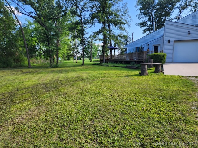 14360 County Road 3505th Loop, Ada, OK 74820 - view of green lawn featuring a garage, a deck, and concrete driveway