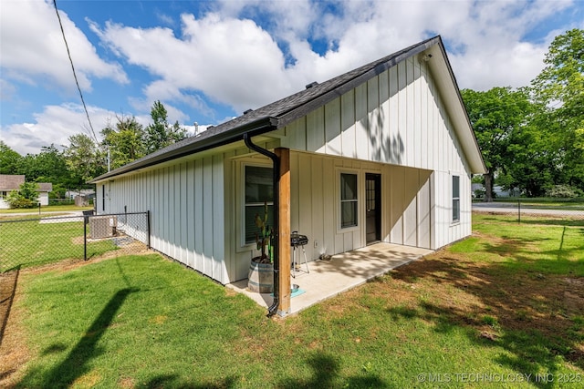 view of side of home featuring a patio area, board and batten siding, and a shingled roof