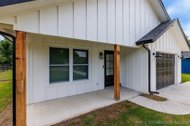 view of front of property with a garage, board and batten siding, a porch, fence, and concrete driveway