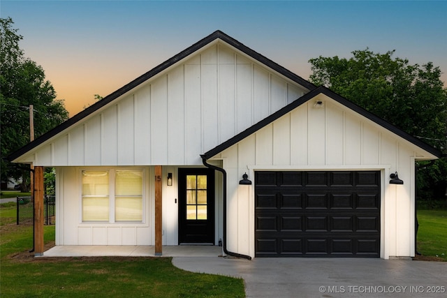 view of front of property featuring concrete driveway, a garage, a front yard, and board and batten siding