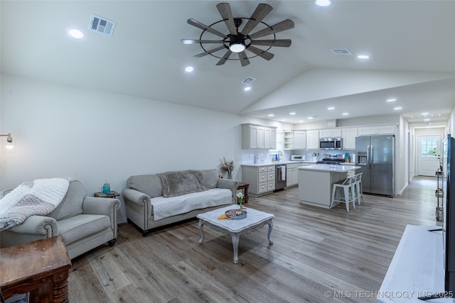 living room featuring ceiling fan, lofted ceiling, light wood finished floors, and recessed lighting