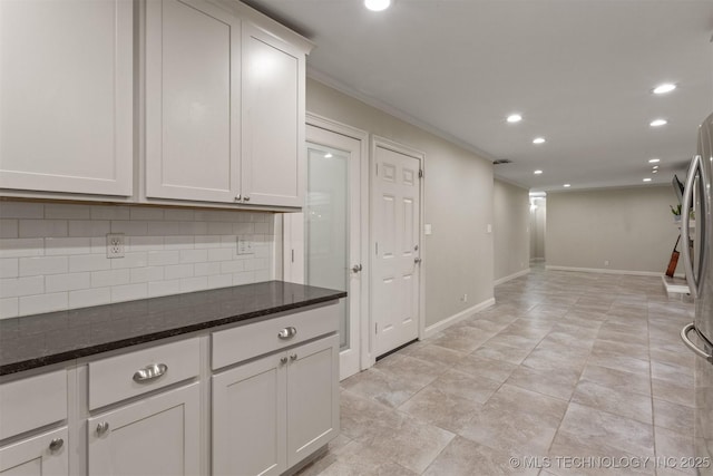 kitchen with ornamental molding, decorative backsplash, recessed lighting, dark stone countertops, and baseboards