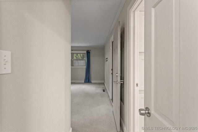 corridor with light carpet, baseboards, and ornamental molding