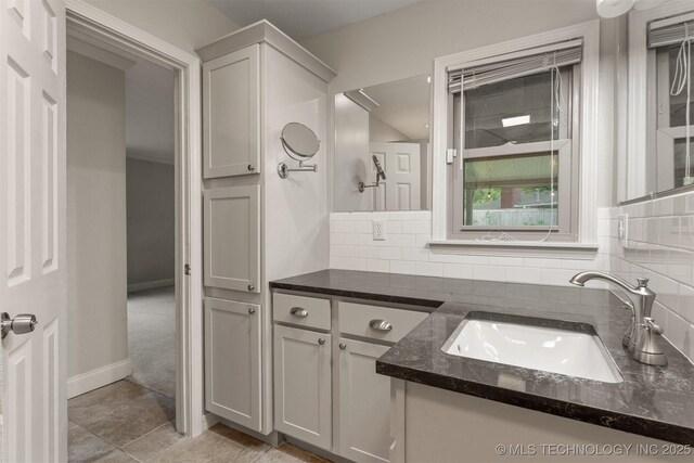 bathroom featuring tasteful backsplash, vanity, and baseboards