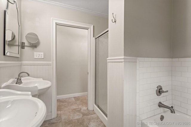 bathroom with crown molding, a wainscoted wall, an enclosed shower, and a tub to relax in