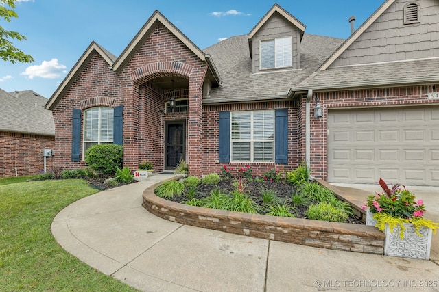 9401 N 95th E Pl, Owasso, OK 74055 - view of front of home featuring brick siding, a shingled roof, an attached garage, a front yard, and concrete driveway
