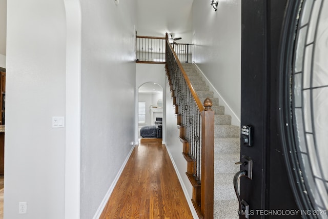 9401 N 95th E Pl, Owasso, OK 74055 - entrance foyer with arched walkways, wood finished floors, ceiling fan, stairs, and a fireplace