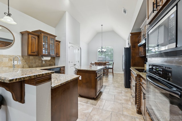 9401 N 95th E Pl, Owasso, OK 74055 - kitchen with oven, built in microwave, a center island, lofted ceiling, and light stone counters