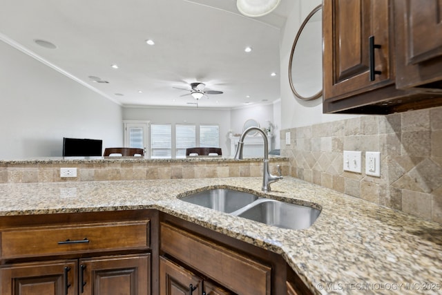 9401 N 95th E Pl, Owasso, OK 74055 - kitchen with a sink, crown molding, light stone counters, a ceiling fan, and backsplash