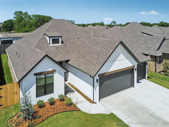 view of front facade with a shingled roof, fence, driveway, an attached garage, and stucco siding