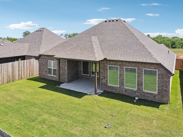 rear view of property featuring roof with shingles, a patio, and brick siding