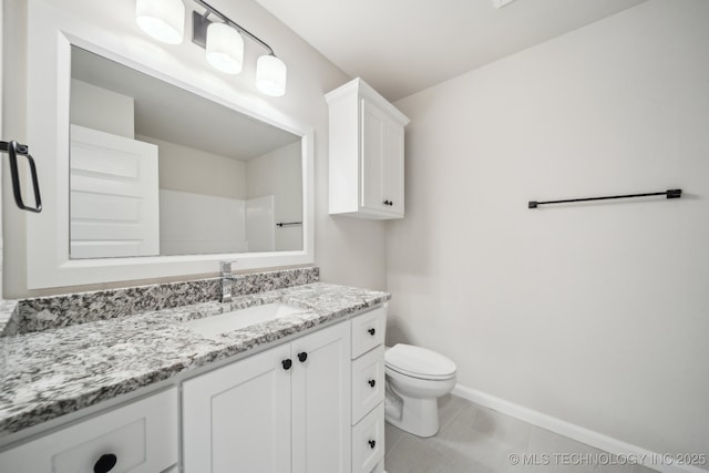 bathroom featuring vanity, toilet, and baseboards