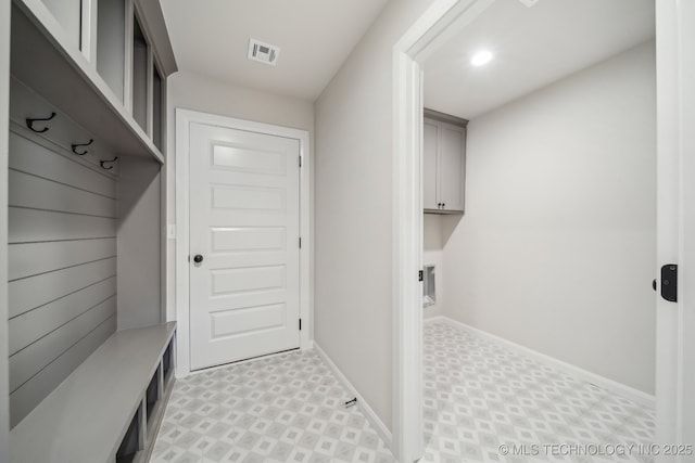 mudroom featuring light flooring and baseboards