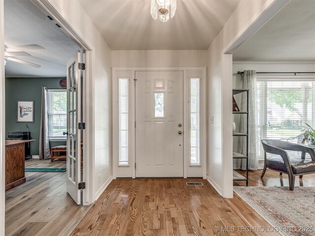 foyer with baseboards, light wood-type flooring, and ceiling fan