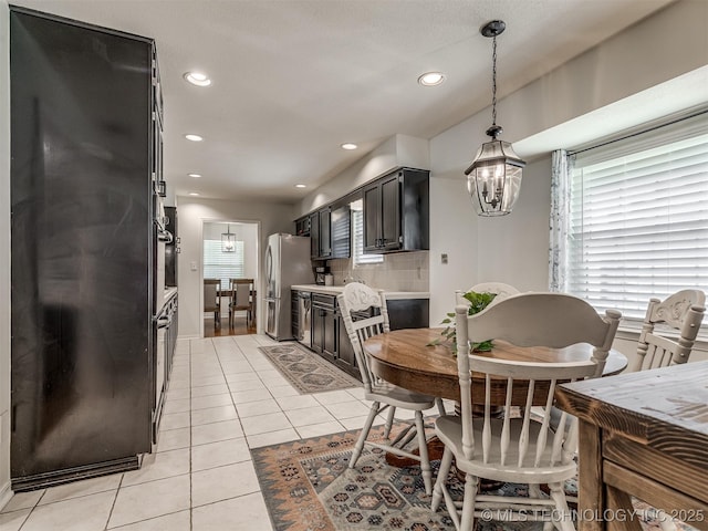 dining space featuring light tile patterned flooring, a chandelier, and recessed lighting