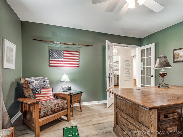 sitting room featuring light wood-style flooring, a ceiling fan, baseboards, and french doors