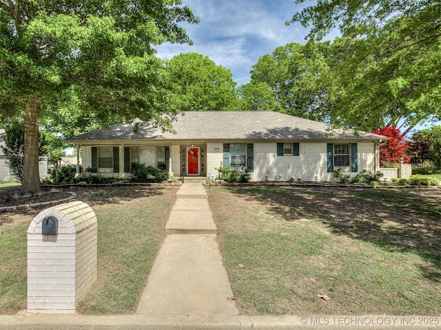 single story home featuring brick siding and a front yard
