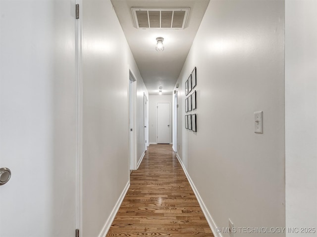 corridor featuring wood finished floors and baseboards