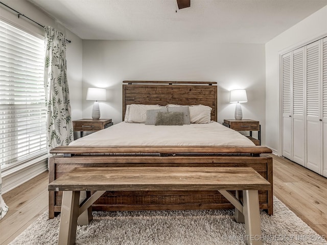 bedroom with light wood finished floors, baseboards, and ceiling fan