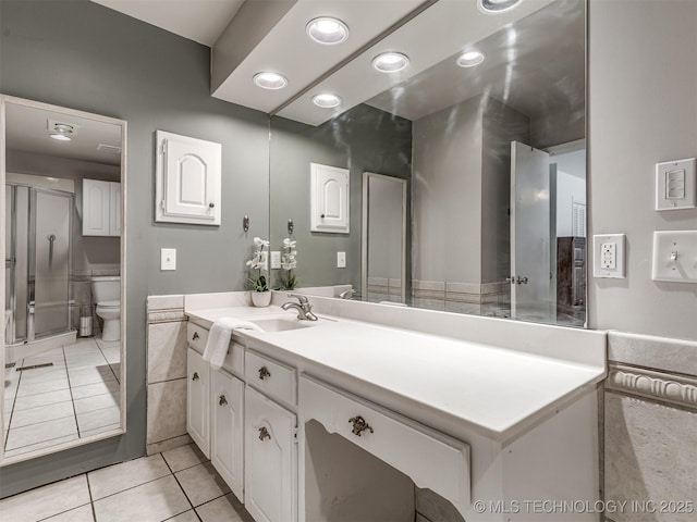 bathroom featuring tile patterned floors, toilet, vanity, an enclosed shower, and recessed lighting