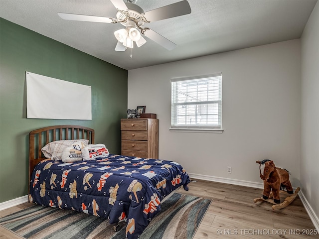 bedroom featuring wood finished floors, baseboards, and a ceiling fan