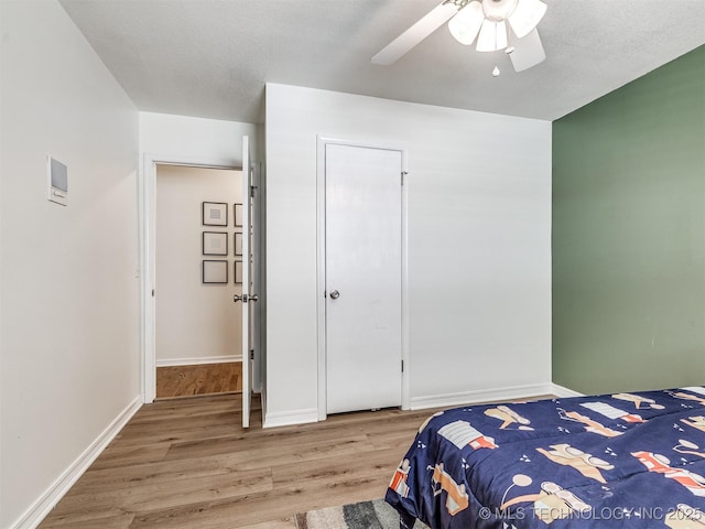 bedroom with wood finished floors, ceiling fan, and baseboards