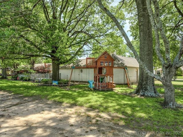 rear view of house featuring a playground and a chimney