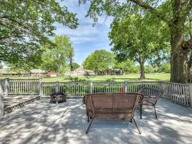 deck with a yard and an outdoor living space with a fire pit