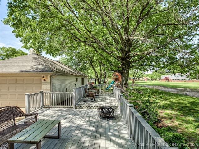wooden deck with an outdoor fire pit and a playground
