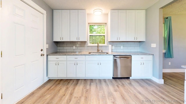917 Fairway, Sulphur, OK 73086 - kitchen featuring dishwasher, a sink, tasteful backsplash, white cabinets, and a textured ceiling
