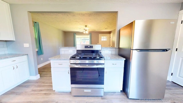 917 Fairway, Sulphur, OK 73086 - kitchen featuring stainless steel appliances, white cabinets, light stone counters, light wood-style flooring, and a textured ceiling