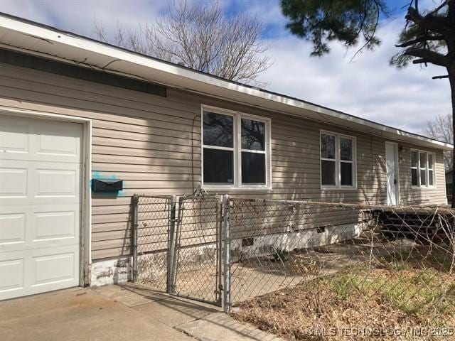 2643 E Haskell St, Tulsa, OK 74110 - view of property exterior with a gate, fence, an attached garage, and crawl space
