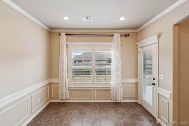 tiled empty room featuring a decorative wall, plenty of natural light, wainscoting, ornamental molding, and recessed lighting
