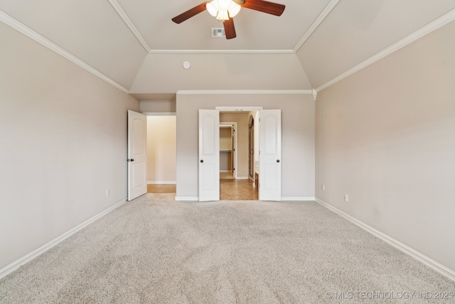 unfurnished bedroom featuring carpet flooring, baseboards, a spacious closet, crown molding, and ceiling fan