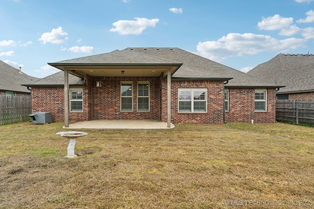 back of house with brick siding, roof with shingles, and a patio