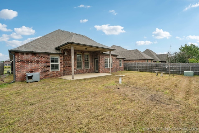 back of property with a patio, brick siding, and a shingled roof