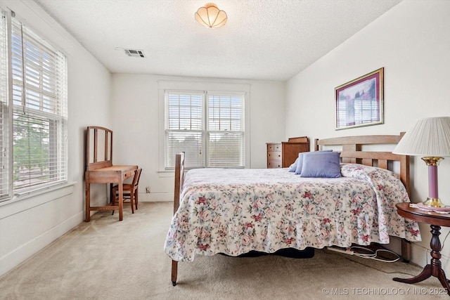 1032 E Mcleod Ave, Sapulpa, OK 74066 - bedroom featuring multiple windows, light colored carpet, and a textured ceiling