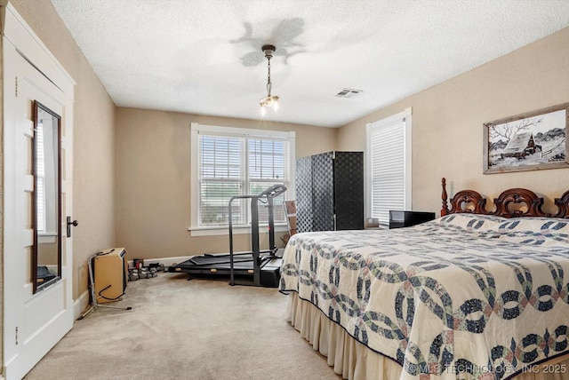 bedroom with light colored carpet, a textured ceiling, and baseboards